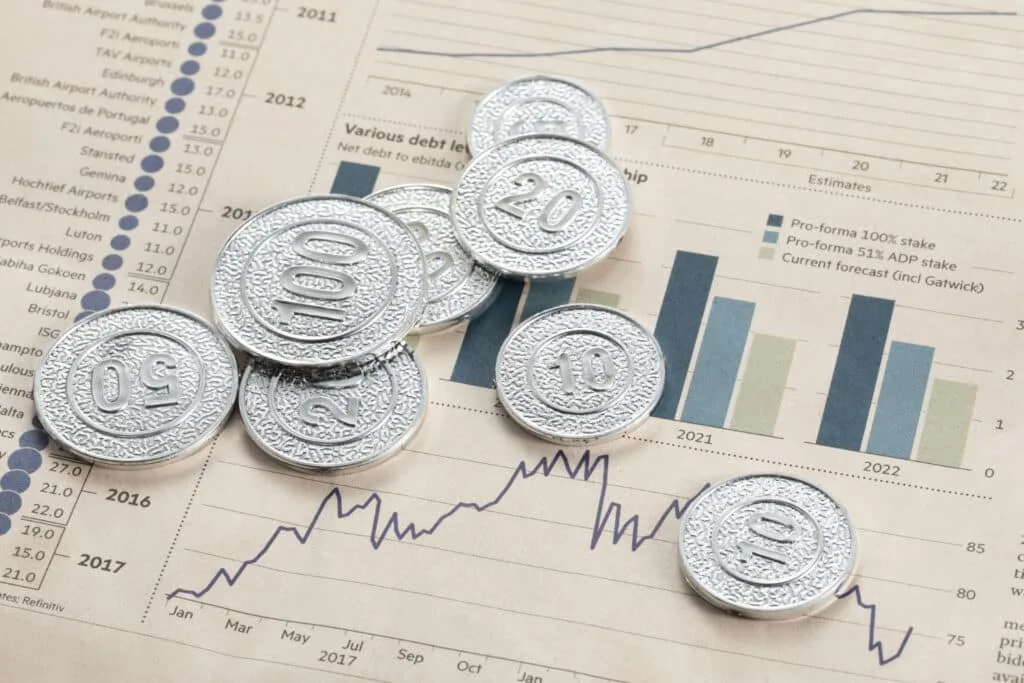 coins on top of a white paper with stock market graph