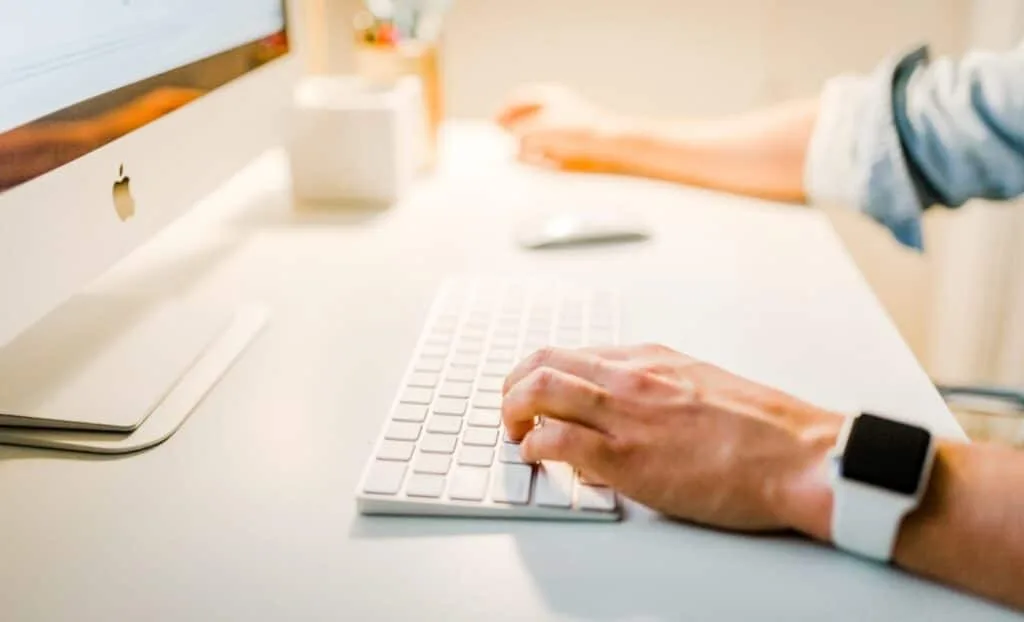 man with an apple watch working on a computer