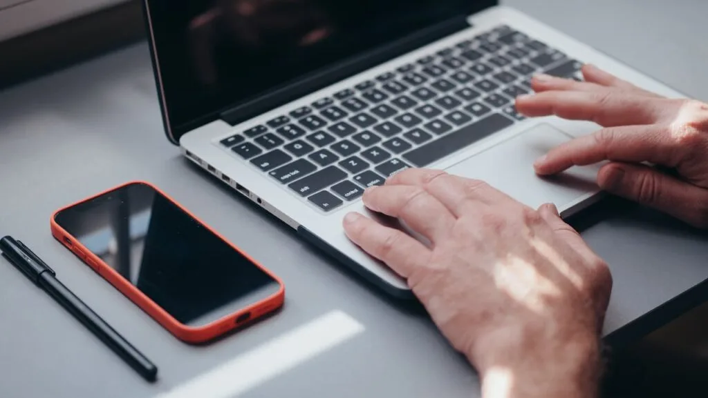 man typing on a laptop
