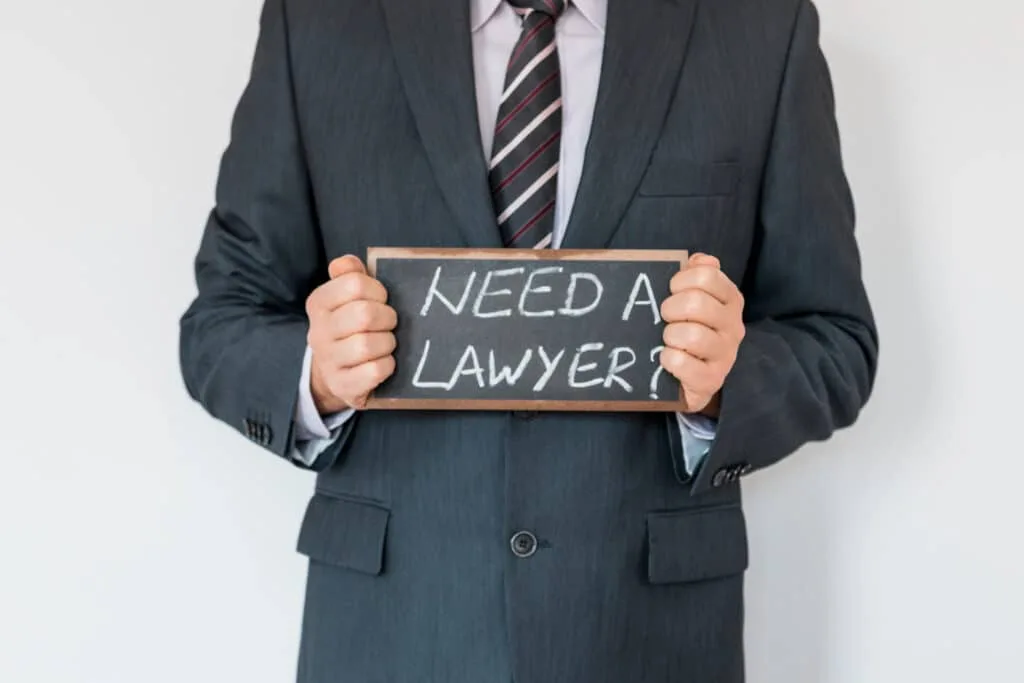 man holding a 'need a lawyer' sign