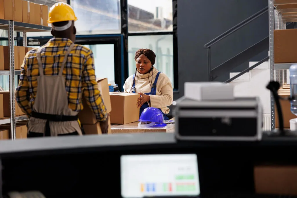 Woman package handler putting cardboard box on table