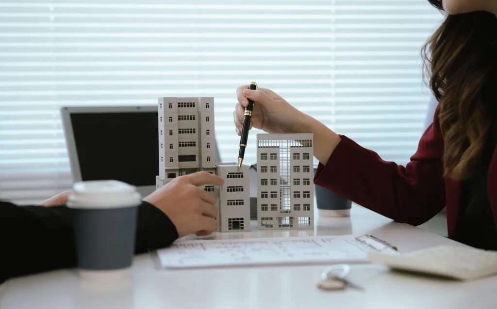 hands pointing at condo building models