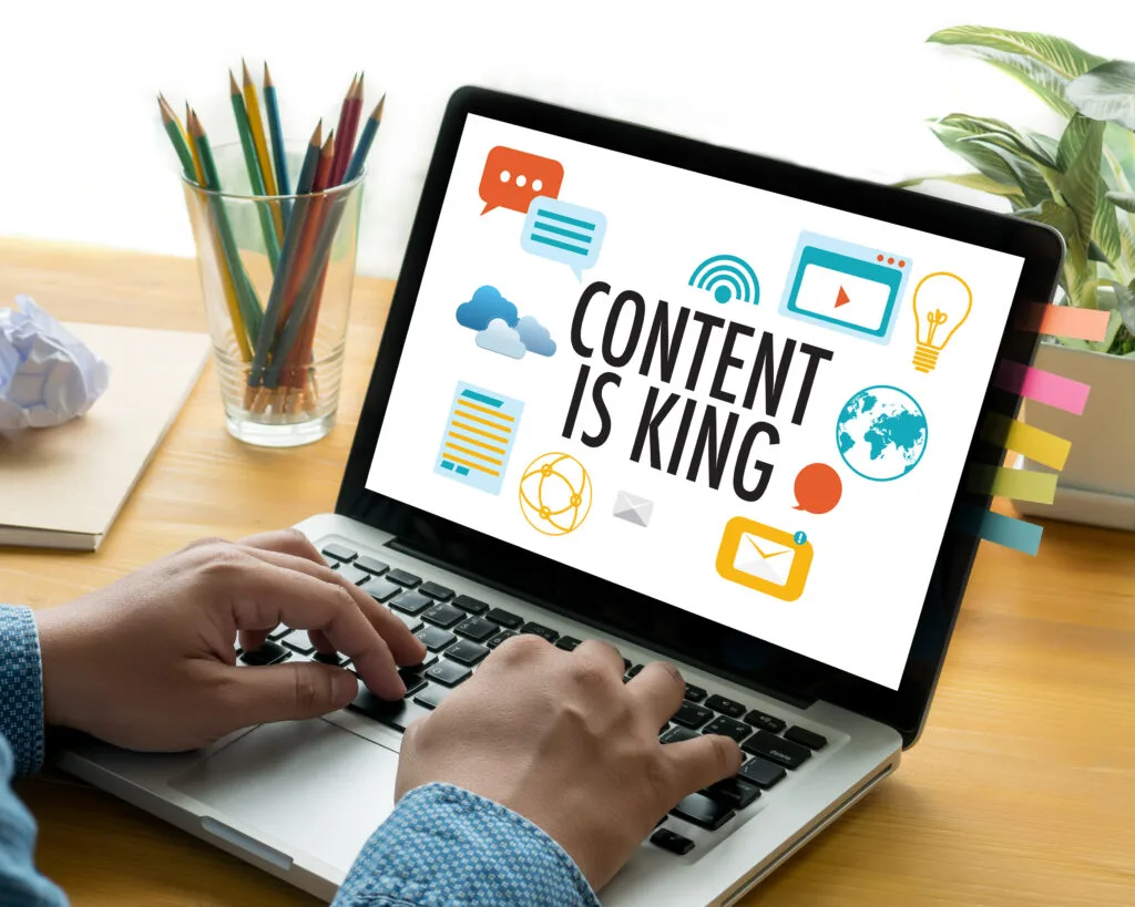 man working on a laptop with &quot;Content is King&quot; displayed as his wallpaper