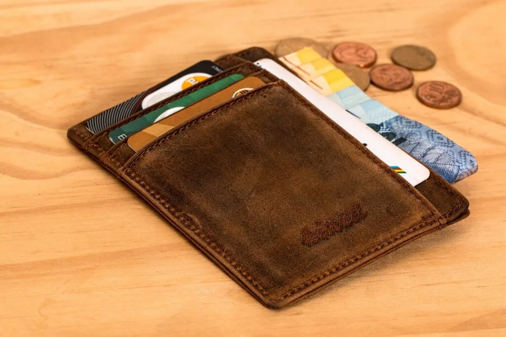 brown leather wallet with money on top of a table