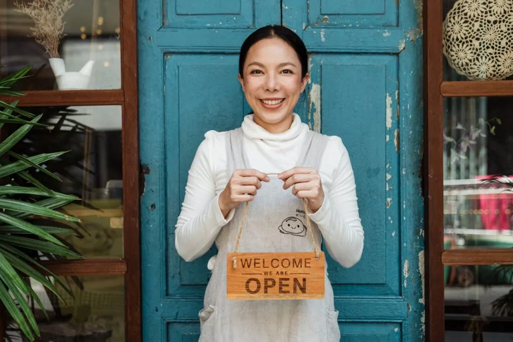 Woman holding opening store signage