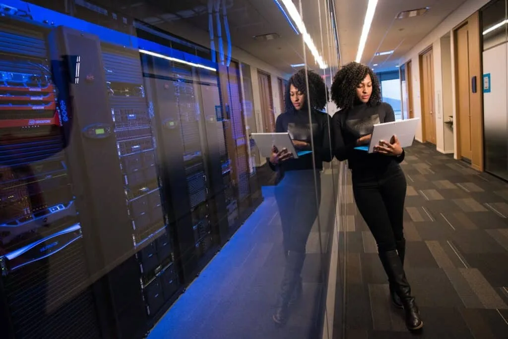 A woman holding a laptop on a cloud server center.
